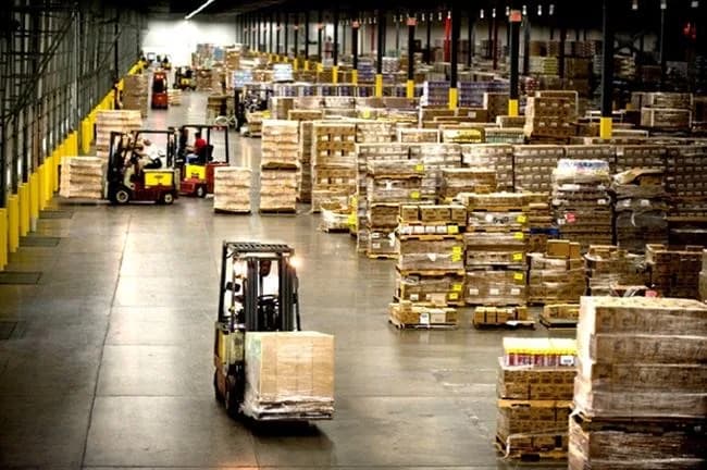 Forklifts moving palletised stock down the aisle of a distribution warehouse